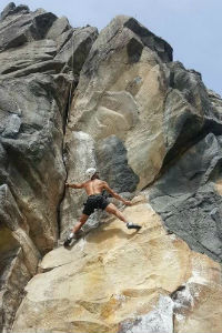 Young man rock climbing..